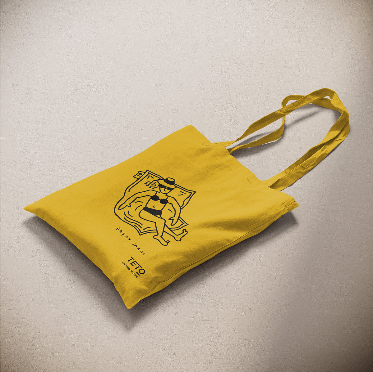 Tote bag in canvas Giallo con illustrazione Pouf di Başak Saral (donna che prende il sole sdraiata sul pouf), vista laterale – TETO