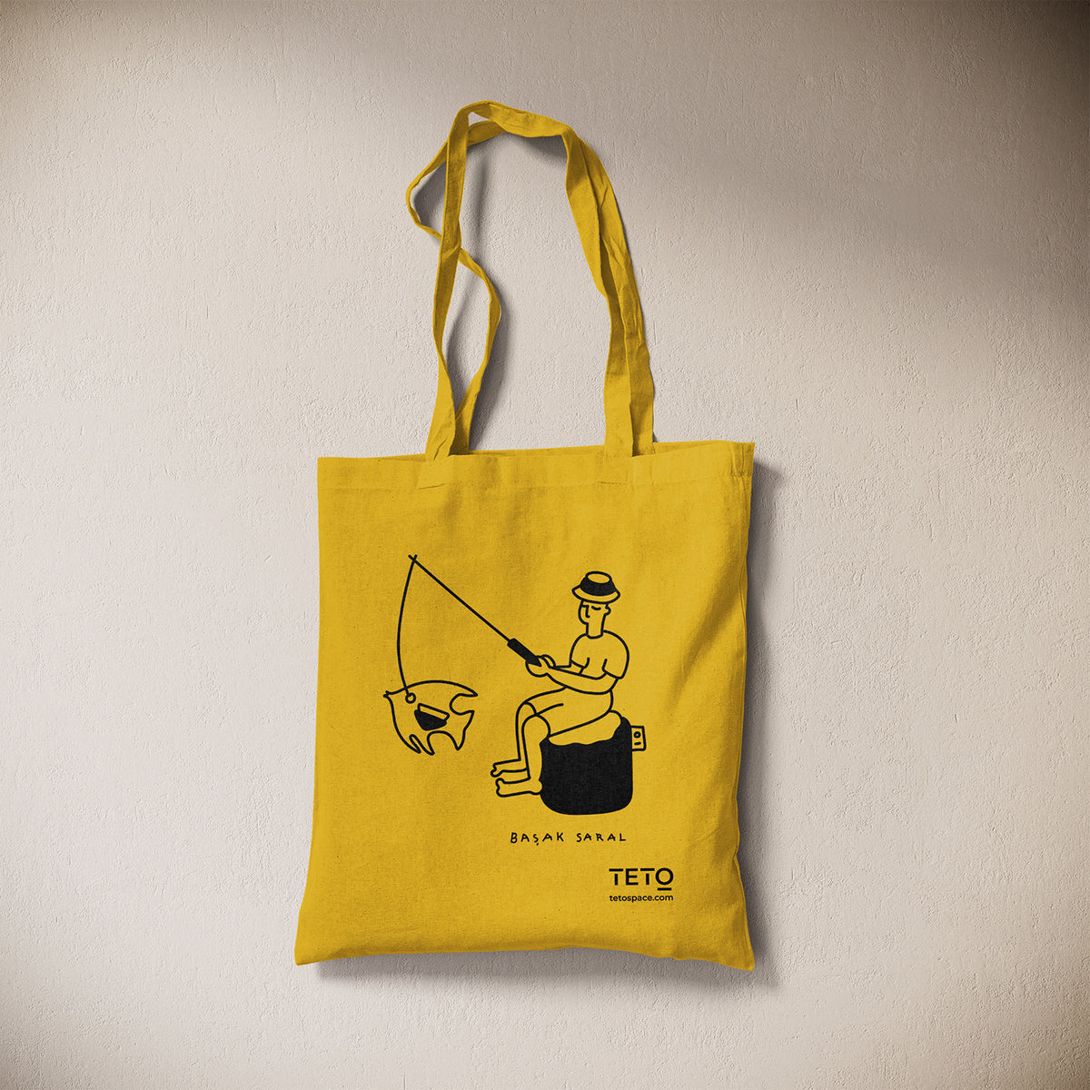 Tote bag in canvas Giallo con illustrazione Fish di Başak Saral (pescatore seduto sul pouf), vista frontale – TETO