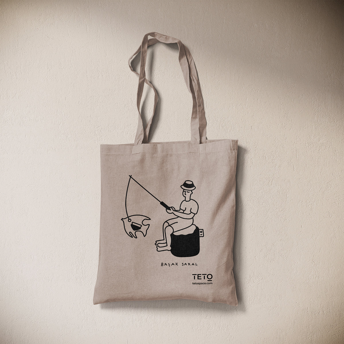 Tote bag in canvas Grigio con illustrazione Fish di Başak Saral (pescatore seduto sul pouf), vista frontale – TETO