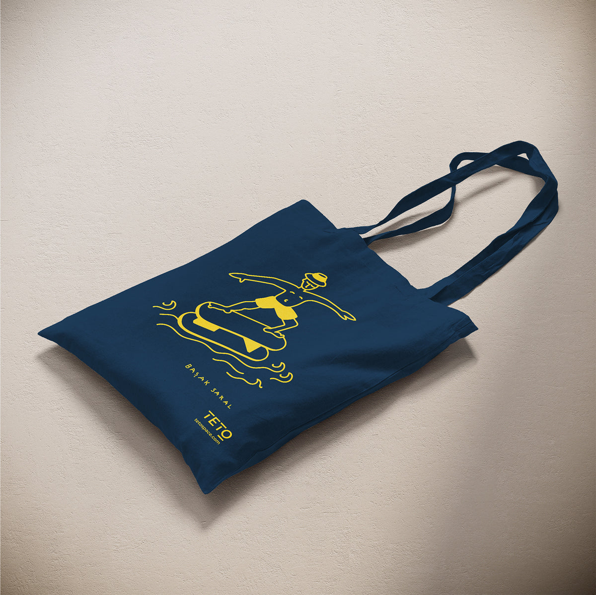 Tote bag in canvas Blu con illustrazione Serf di Başak Saral (surfista sul pouf tra le onde), vista laterale – TETO