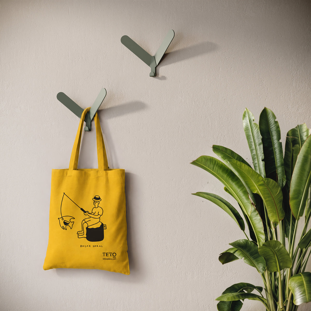 Tote bag in canvas Giallo con illustrazione Fish di Başak Saral (pescatore seduto sul pouf), ambientata – TETO