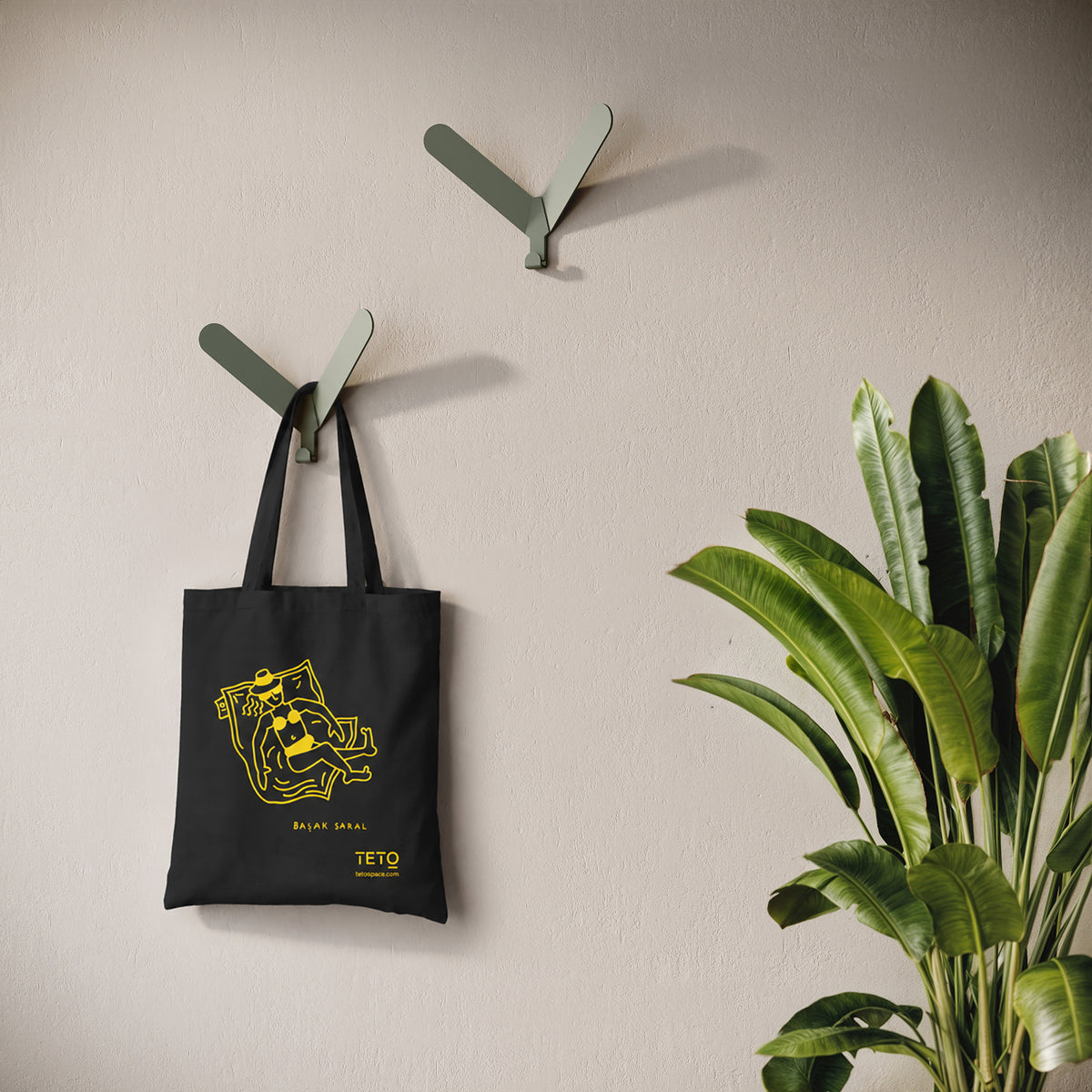 Tote bag in canvas Nero con illustrazione Pouf di Başak Saral (donna che prende il sole sdraiata sul pouf), ambientata – TETO